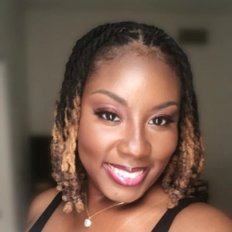 Photo of woman with brown and blonde locs smiling